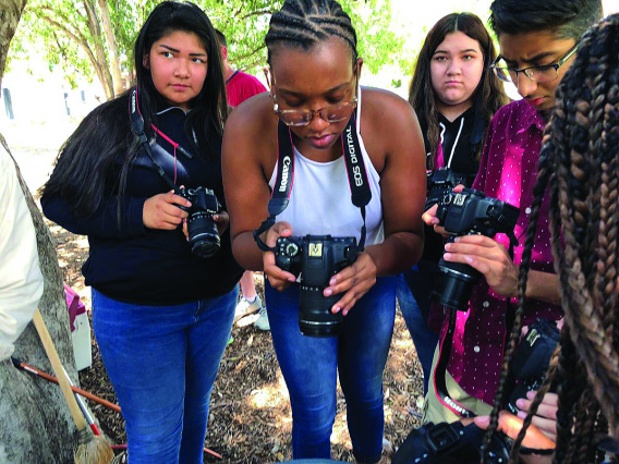 Minority high school students using camera