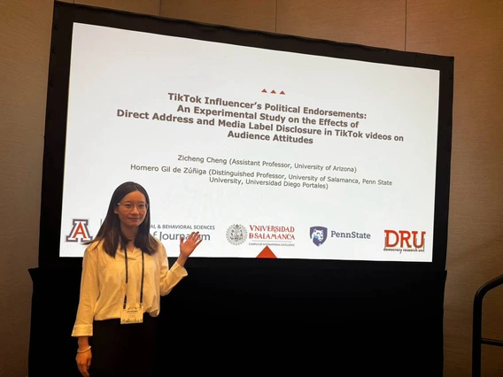 Professor Zicheng Cheng poses in front of research presentation screen