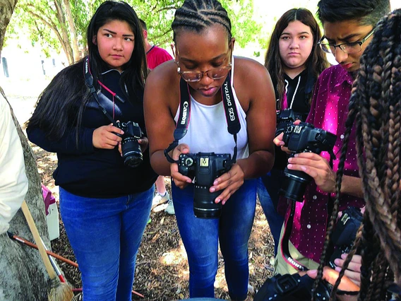 Minority high school students using camera