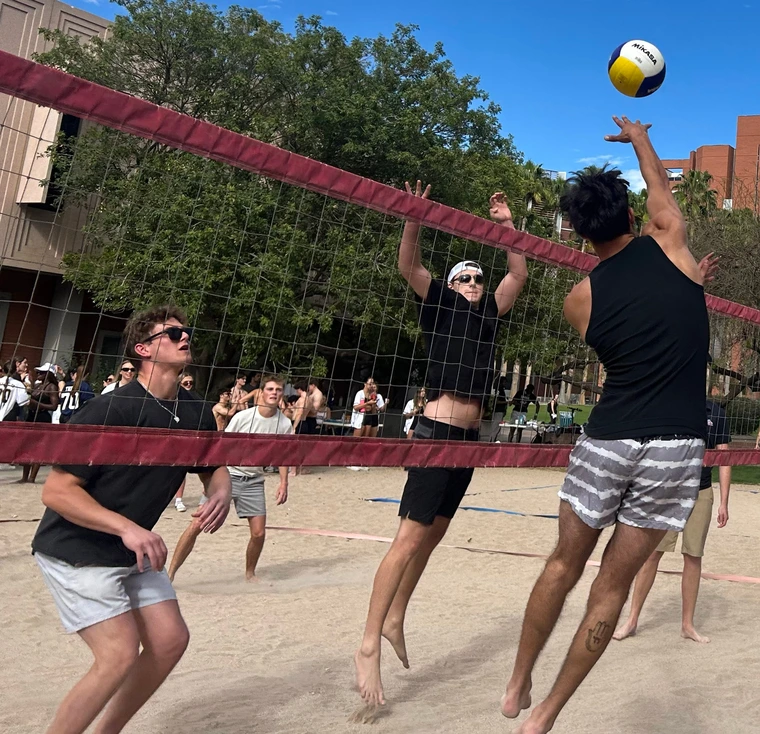 Students play beach volleyball