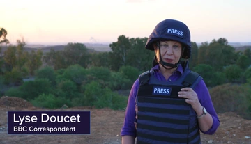 Lyse Doucet stands in protective press gear in Israel