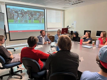 Guest speaker sits with students in class