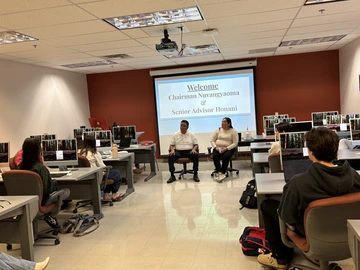 Two guest speakers sit in classroom 