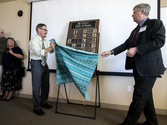 Director David Cuillier and Mike Chesnick, outreach coordinator, unveil the school's Hall of Fame plaque.