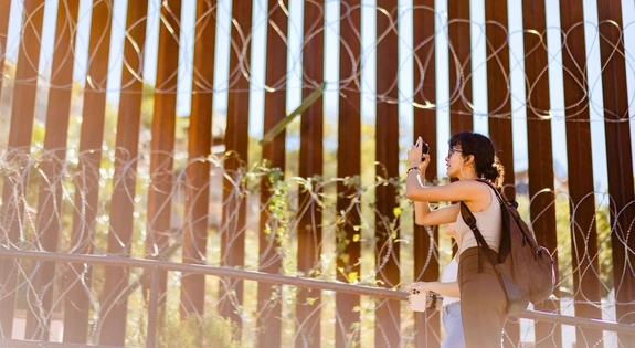 Students take photo of the border wall