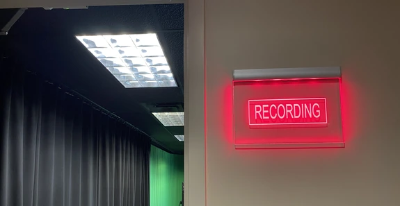 Broadcast studio recording sign lit up