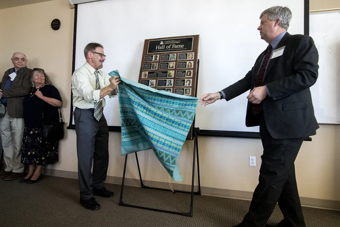 Director David Cuillier and Mike Chesnick, outreach coordinator, unveil the school's Hall of Fame plaque.