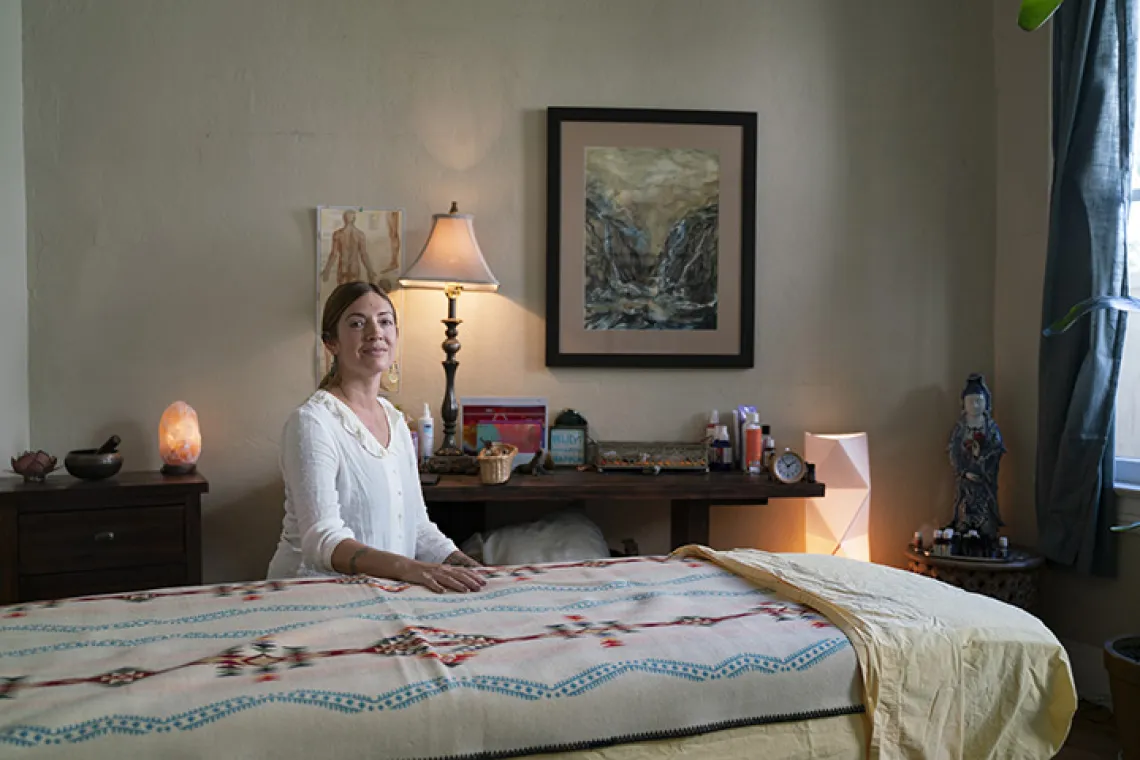 Woman sitting next to massage table