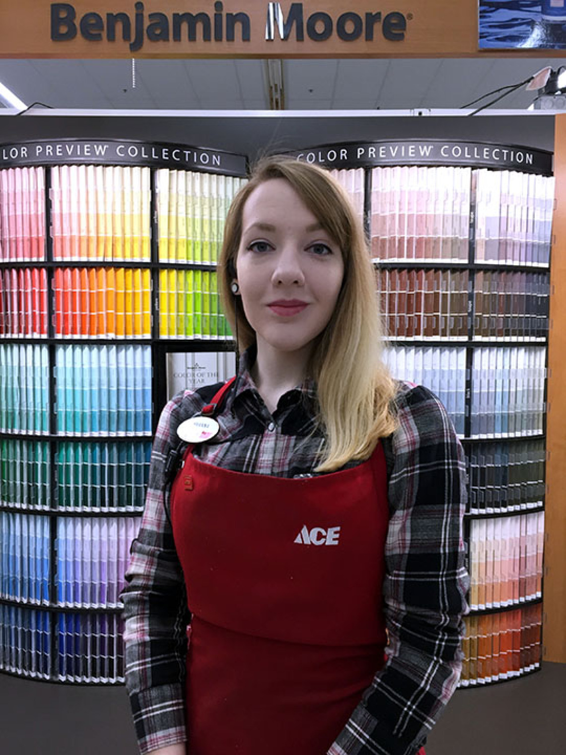 Ace Hardware employee in front of paint samples