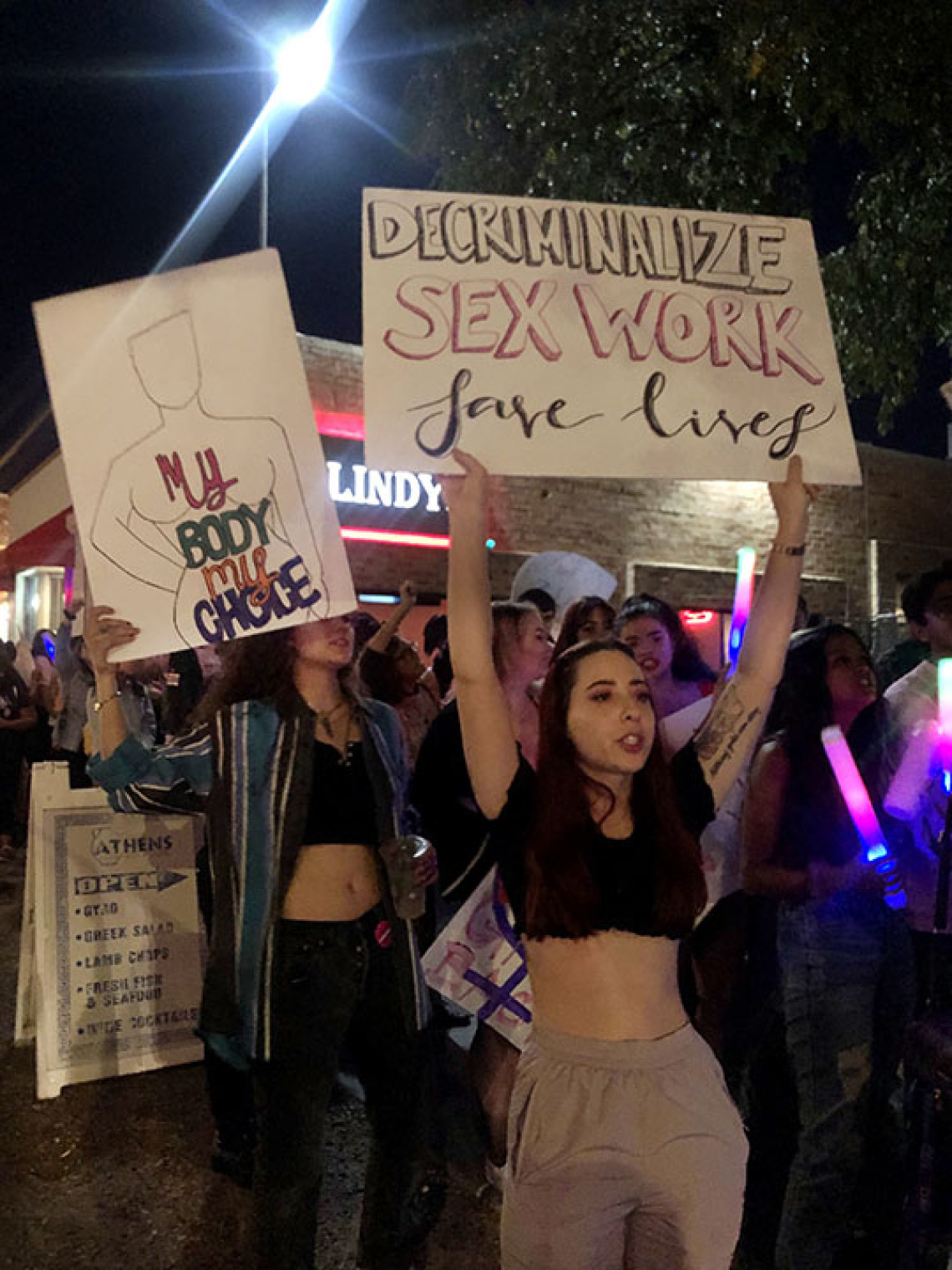 Woman holding sign to decriminalize sex work