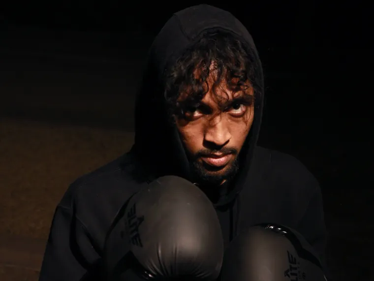 A boxer holds up his gloves