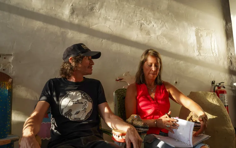 Two people sit in chairs illuminated by sunlight