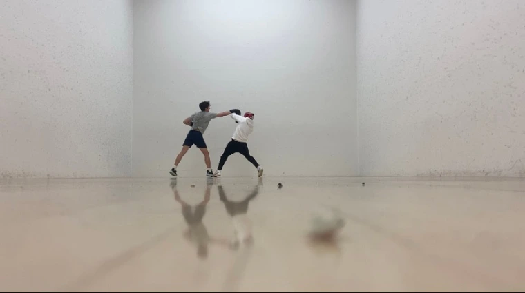 Two men box in an empty room
