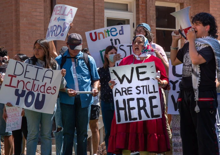 Protestors hold signs on the university campus