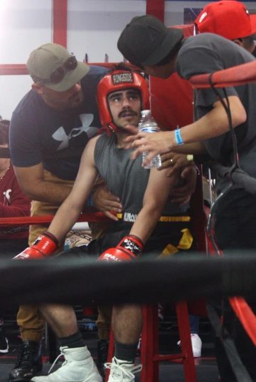 A boxer talks to a coach in a boxing ring