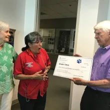 Carol and Cecil Schwalbe give award to staff member